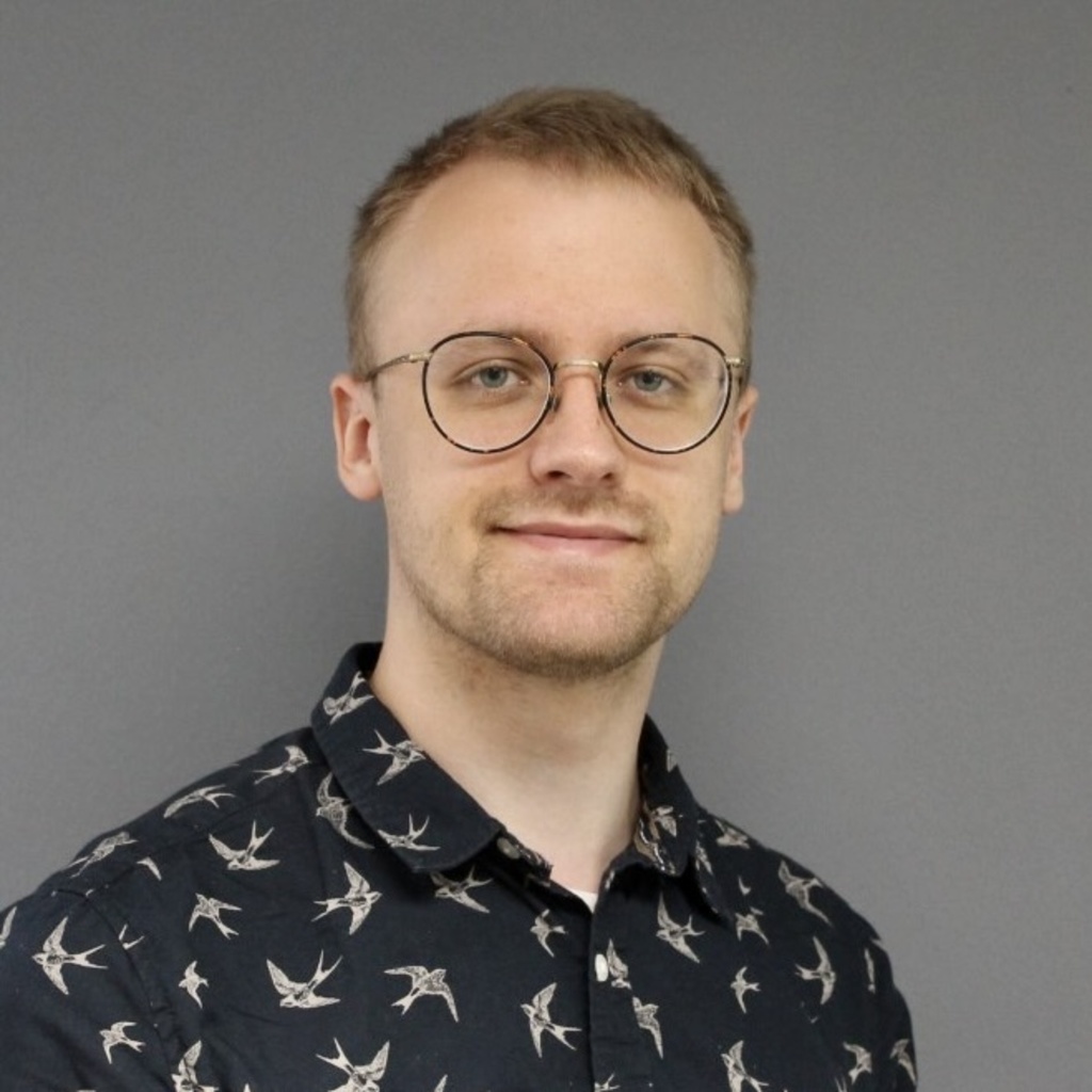 I have blond hair, round glasses, and am wearing a navy blue shirt.