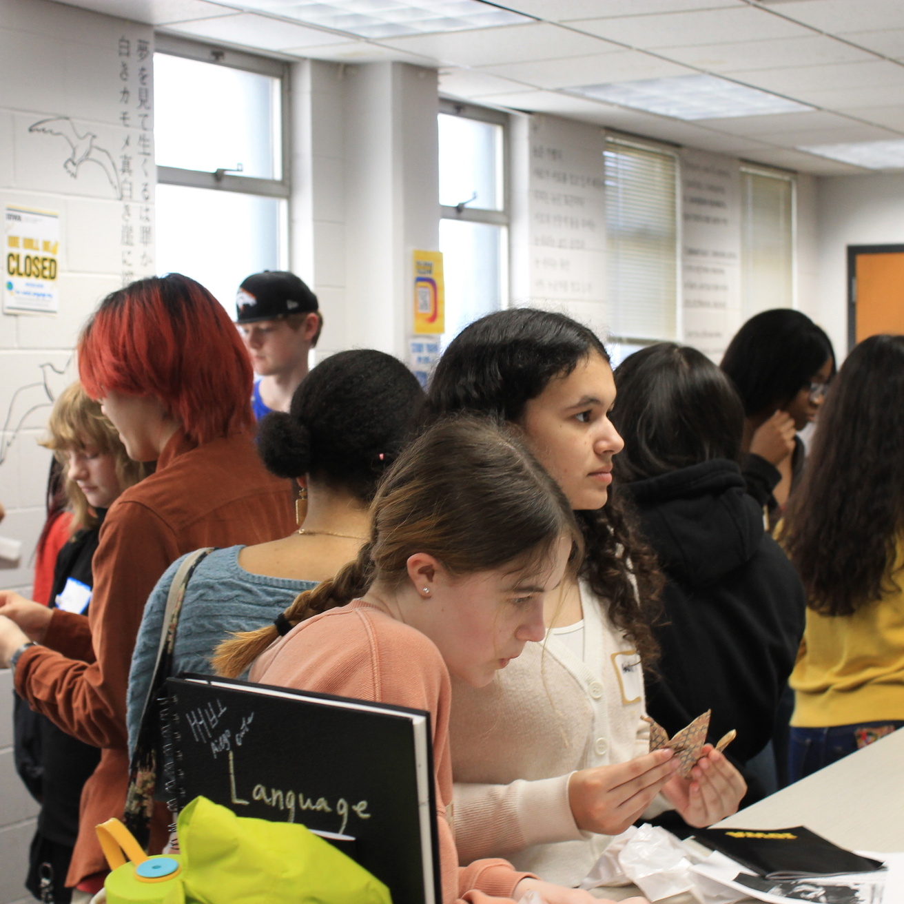high school students interacting with faculty and staff at World Language Day tables