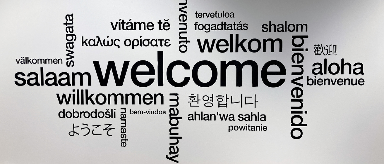 Entry wall of the Center for Language and Culture Learning, showing the word Welcome in various languages.