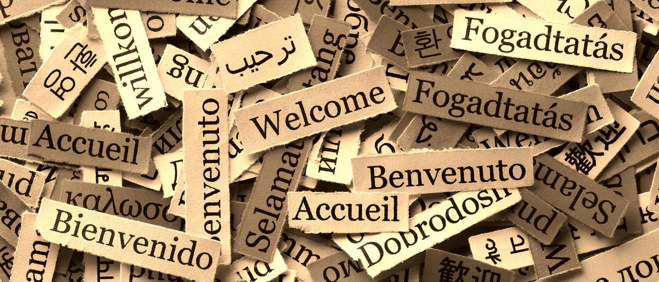The word Welcome written on document paper in various world languages.