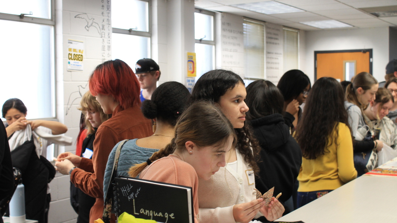 high school students interacting with faculty and staff at World Language Day tables
